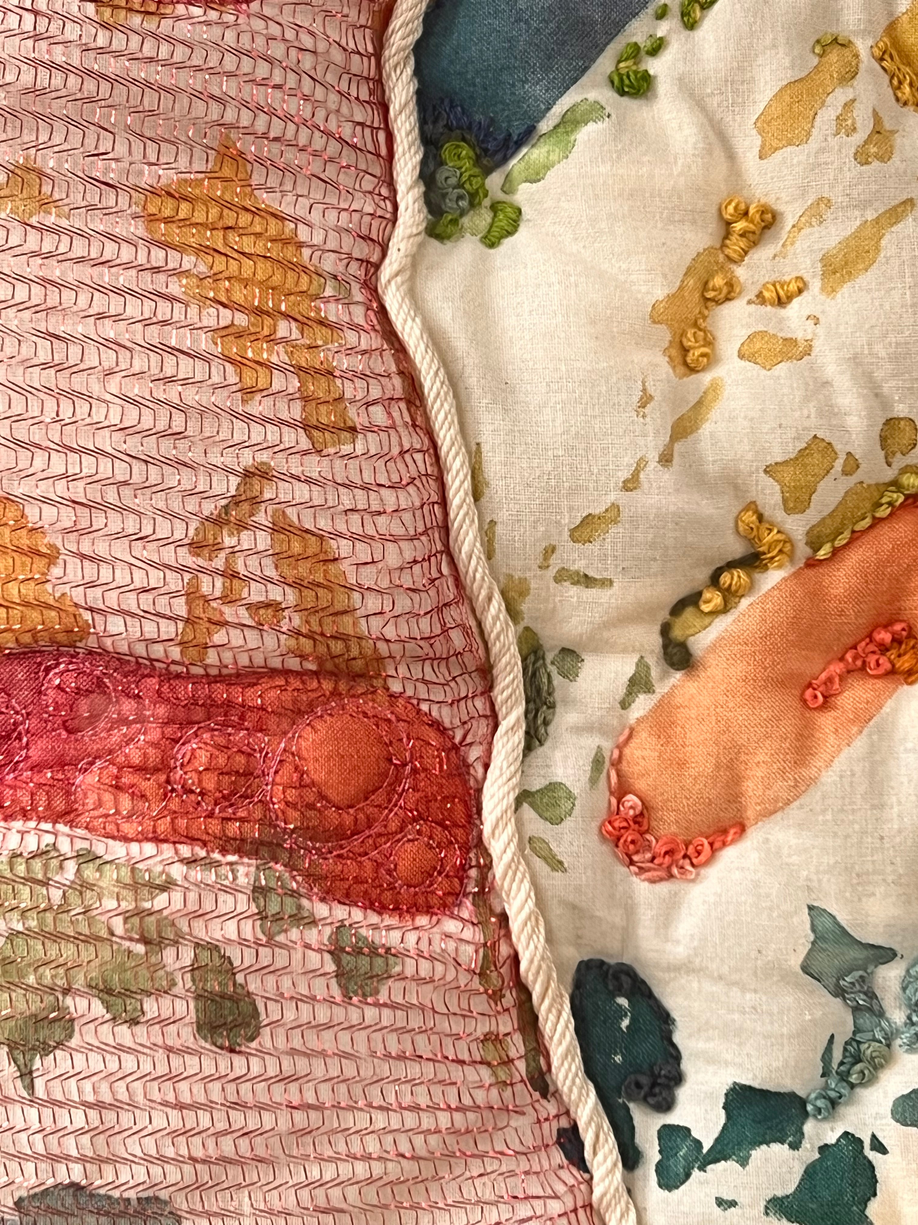 Close-up of embroidered fabric with floral patterns and colorful stitches.